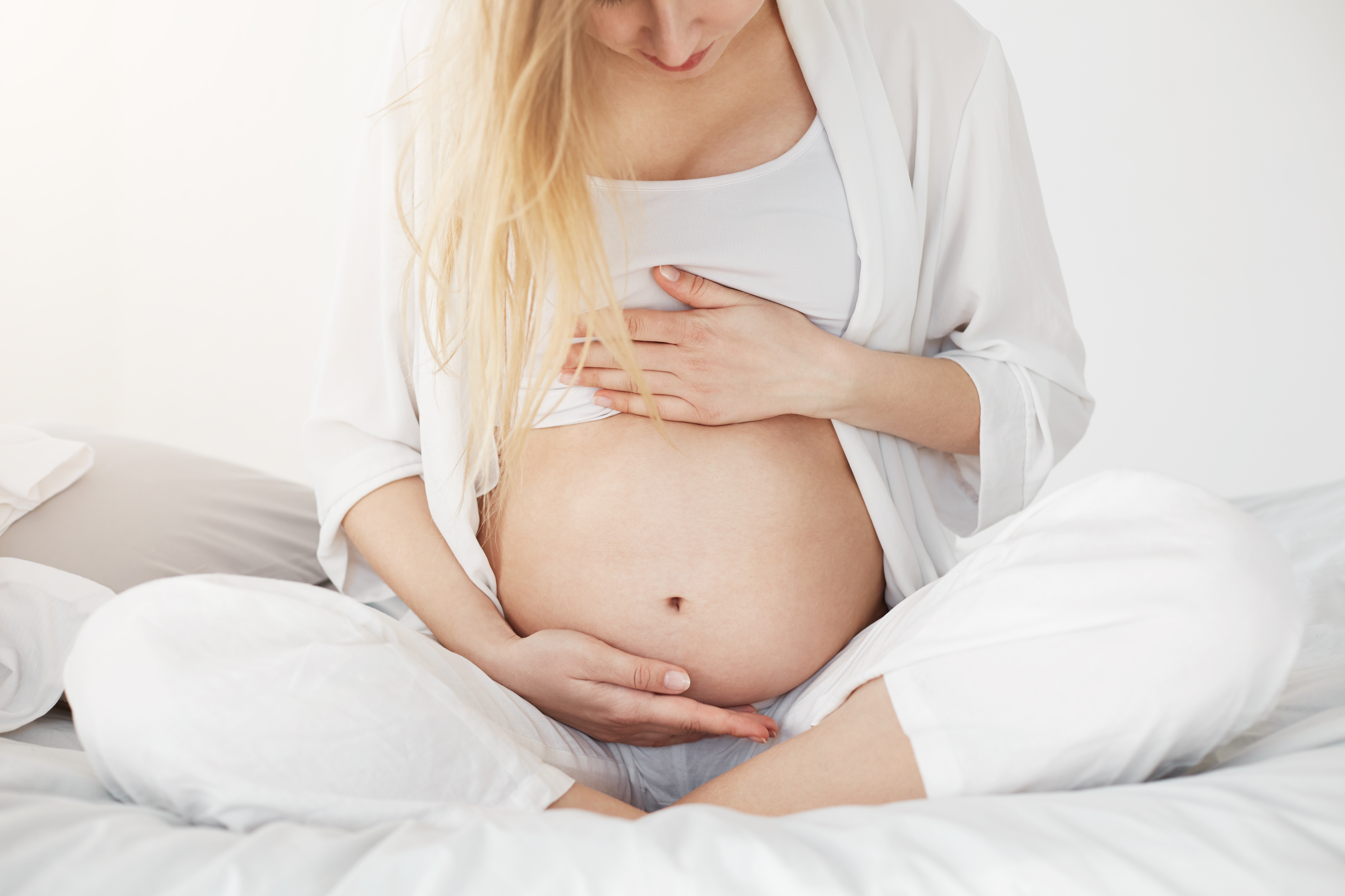 Donna incinta serena, mani appoggiate sulla pancia